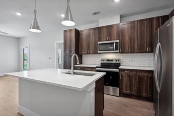 kitchen with wooden cabinets and a white counter top at The Virginia, Texas